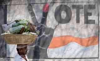 A vegetable vendor walks past graffiti urging Indians to vote, in Mumbai. (INDRANIL MUKHERJEE/AFP/Getty Images)