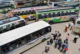 

Passengers waiting to board private buses. (Photo Credit:MANJUNATH KIRAN/AFP/Getty Images)