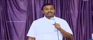 

Mohan C Lazarus delivers a speech. (YouTube)