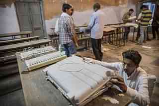 An election worker closes up an EVM before sealing it after the final polls closed in Varanasi, India. (Kevin Frayer/GettyImages)