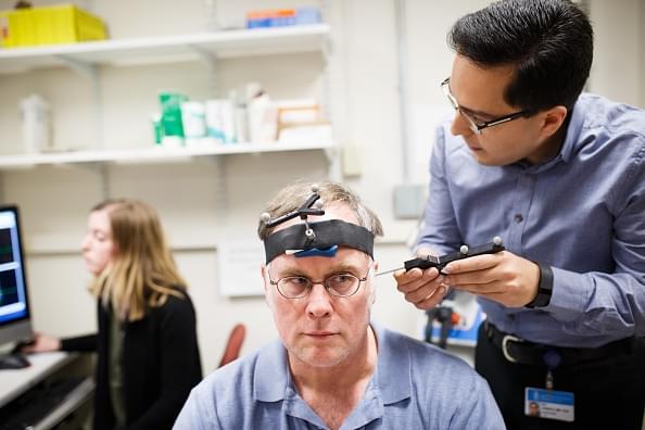 Research fellow Ali Jannati simulates a TMS therapy session on John Elder Robison as he sits in the room where he took part in brain therapy known as TSM (Transcranial magnetic stimulation) at Beth Israel Hospital in Boston, Mass. (Keith Bedford/The Boston Globe via Getty Images)