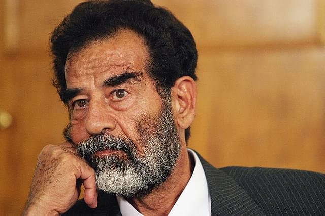 Saddam Hussein listens as a list of charges that he  will face is read in an Iraqi courtroom July 1, 2004 in Baghdad, Iraq. (Photo by Pool-Getty Images)