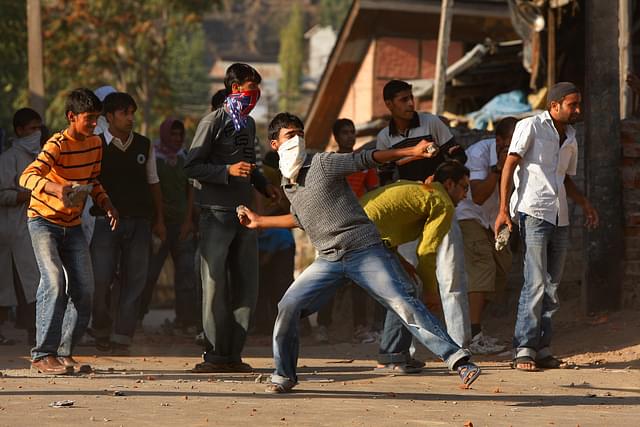 Youngsters pelting stones at the Army in the Kashmir Valley (Paula Bronstein/Getty Images)