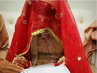 A Muslim bride signs a marriage register