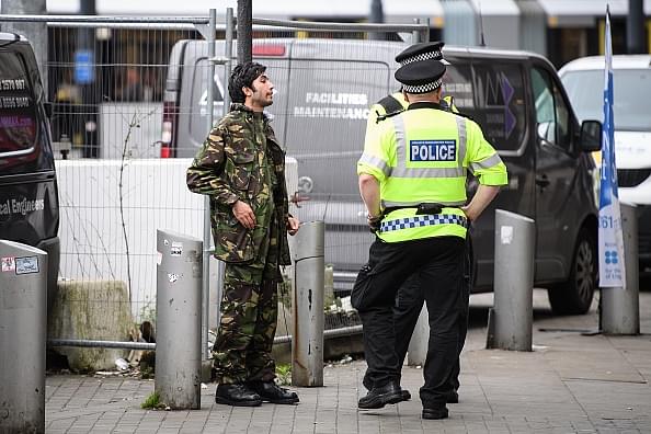 A man is stopped and searched by police as he walks in the city centre in Manchester, England. (Leon Neal/Getty Images)