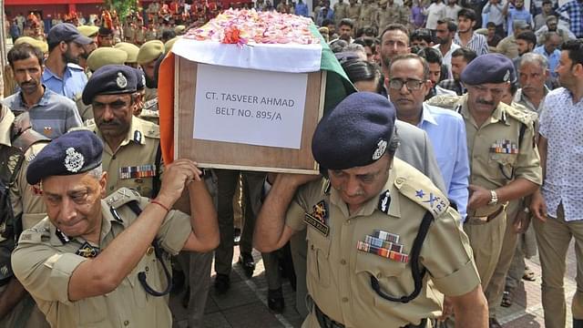 
Senior J&amp;K police officers carry a coffin containing the body of a slain policeman.

