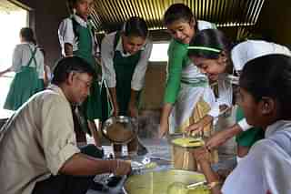 School girls receive a free mid-day meal at a government school. (Anuwar Ali Hazarika / Barcroft I via Getty Images)