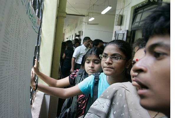 Students scan the merit list put out at their college in Dadar, Mumbai. (Kunal Patil/Hindustan Times via Getty/Images)