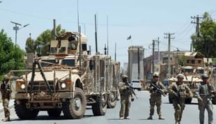 US soldiers stop traffic on the road to the Governor’s compound in Kandahar.