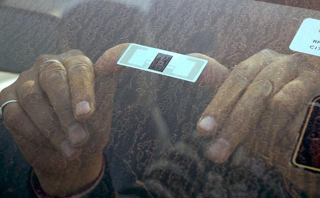 A FASTag RFID tag being affixed on a vehicle (Parveen Kumar/Hindustan Times via Getty Images)