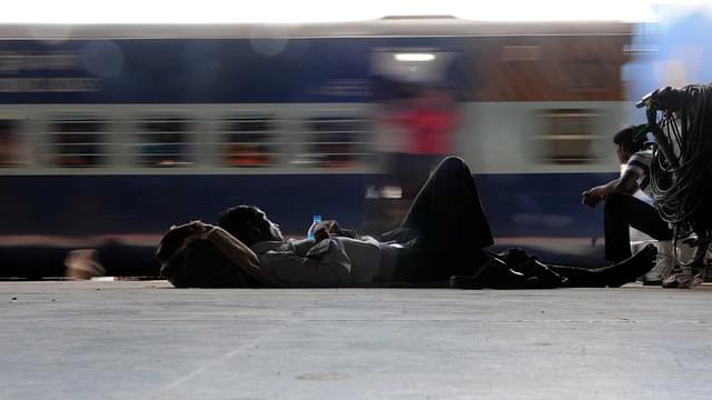 

A passenger sleeps while a train passes by. (Photo by Himanshu Vyas/Hindustan Times via Getty Images)