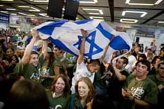 Jewish immigrants from the US wave a flag of Israel as they celebrate their arrival in the terminal hall of Ben Gurion airport near Tel Aviv, Israel. (Uriel Sinai/GettyImages)