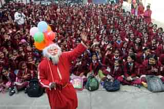 

Children of St. Mary’s Convent Sr. Secondary School make merry with Santa at their school premises during the Christmas celebrations on December 23, 2015 in Bhopal, India. (Photo by Praveen Bajpai/Hindustan Times via Getty Images)