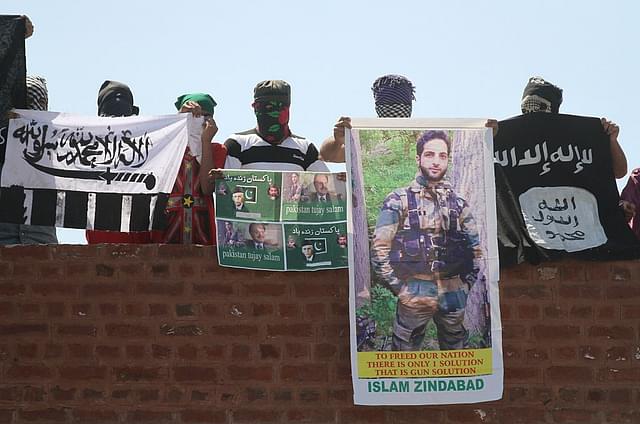 Masked Kashmiri youth hold ISIS, Lashkar-e-Taiba flags and posters of  Mohammad Ali Jinnah and former ISI Chief Hamid Gul and local commander Hizbul Mujahideen Burhan Wani during a protest outside Jamia Masjid in downtown Srinagar (Abid Bhat/Hindustan Times via Getty Images)&nbsp;