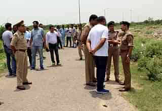 Policemen stand near ATS roundabout, Greater Noida, where a gun battle took place between two criminal gangs and the police. (Shrikumar Bajpai/Hindustan Times)