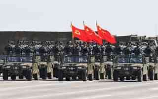 Chinese soldiers carry the flags of (L to R) the Communist Party, the state, and the People’s Liberation Army during a military parade at the Zhurihe training base in China’s northern Inner Mongolia region on July 30, 2017. (STR/AFP/Getty Images)