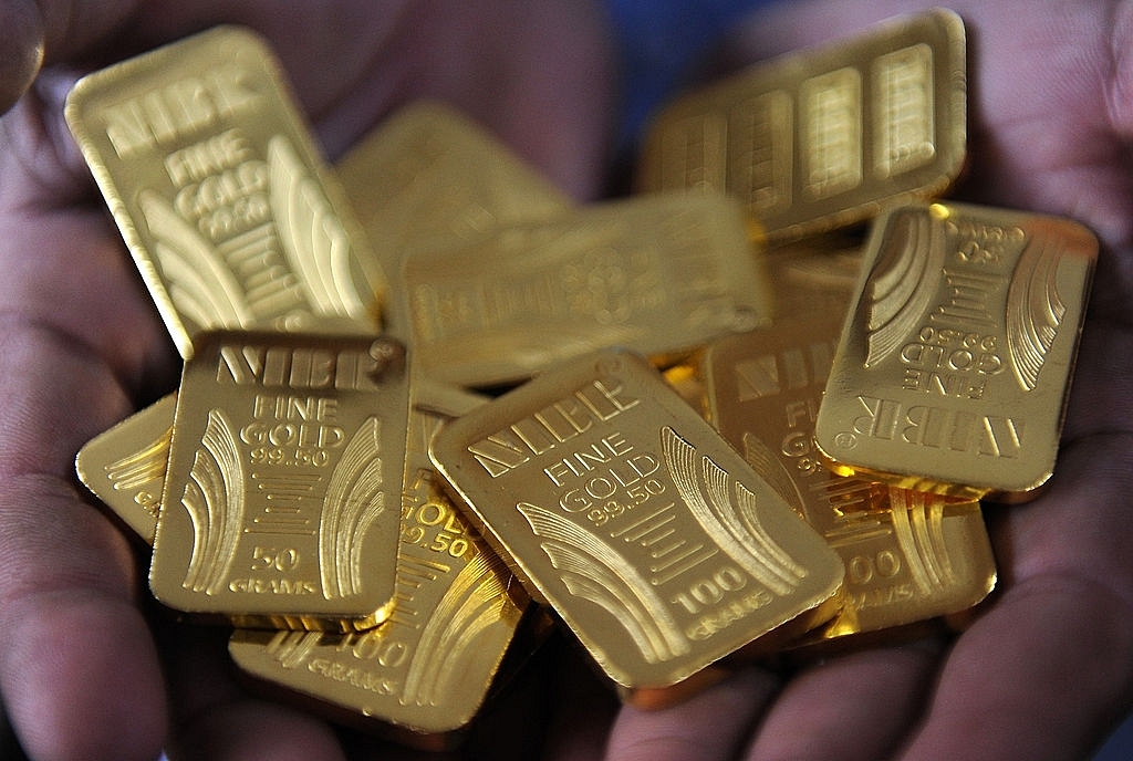 A worker displays gold bars at the National Indian Bullion Refinery (NIBR)‘s gold and silver refinery in Mumbai on November 6, 2009. (INDRANIL MUKHERJEE/AFP/Getty Images)
