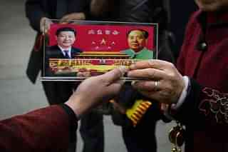 A vendor displays a souvenir with pictures of Chinese President Xi Jinping, left, and the late Mao Zedong. (Feng Li/GettyImages)