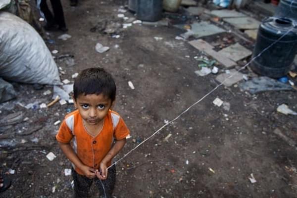 A young girl looks upwards as she plays with a piece of string in Mumbai. (Daniel Berehulak/Getty Images)