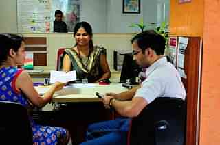 A bank official helps a customer. (Priyanka Parashar/Mint via GettyImages)