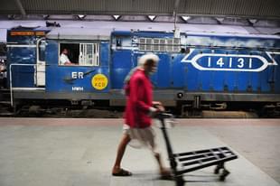 A porter walking in front of a diesel rail engine at Howrah Station on February 26, 2015 in Howrah, India. (Indranil Bhoumik/Mint via Getty Images)