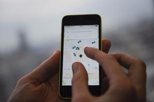 A man holding a smartphone showing the App for ride-sharing cab service Uber. (DANIEL SORABJI/AFP/Getty Images)