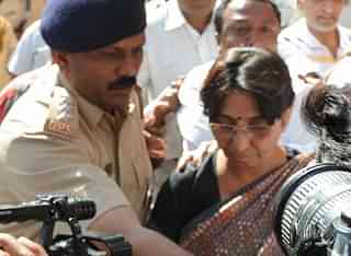 An Indian police officer escorts Kodnani after she surrendered to a special investigation team in Gandhinagar on 27 March 2009. (SAM PANTHAKY/AFP/Getty Images)