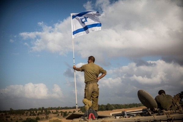 An Israeli soldier stands on top of an armoured personnel carrier near the Israeli-Gaza border in 2014 near Sderot, Israel. (Andrew Burton/Getty Images)