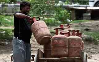An Indian LPG vendor loads refilled gas cylinders onto a rickshaw. (PRAKASH SINGH/AFP/Getty Images)