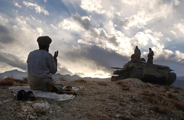 An anti-Taliban soldier
prays near a tank on the hills overlooking the Tora
Bora. (Photo by Chris Hondros/Getty Images)