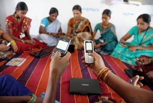 Indian villagers, part of a Self Help Group (SHG) organisation, pose with mobile phones and laptops in Bibinagar village outskirts of Hyderabad on March 7, 2013, on the eve of International Women’s day. (NOAH SEELAM/AFP/Getty Images)