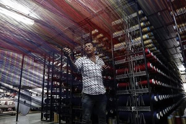 Indian worker checking thread reels on a carpet weaving machine at a factory on the outskirts of Jammu. (ALOK PATHANIA/AFP/Getty Images)
