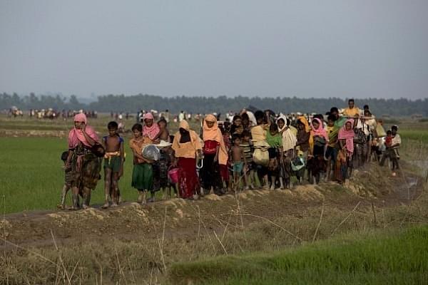 Displaced Rohingya refugees from Rakhine state in Myanmar carry their belongings as they flee violence, near the border between Bangladesh and Myanmar (K M ASAD/AFP/Getty Images)
