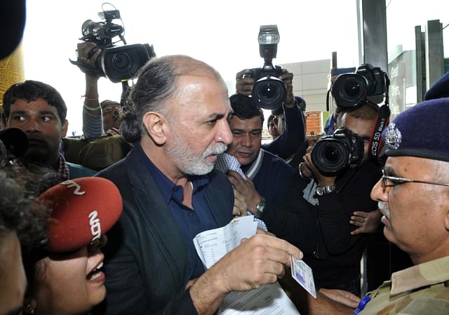  Tarun Tejpal shows his identity card to an official as he enters the airport in New 
Delhi. (STRDEL/AFP/Getty Images)

