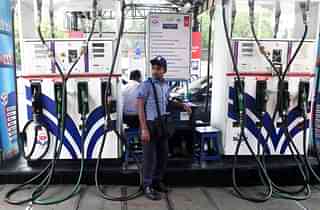 An Indian petrol pump attendant waits for customers at a gas station in Kolkata on June 16, 2017. (DIBYANGSHU SARKAR/AFP/Getty Images)