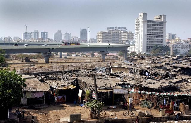 Residents go about their business in a colony of slum dwellings surrounding a newly-built flyover and high-rise apartments in the Bandra suburb of Mumbai. (SEBASTIAN D’SOUZA/AFP/GettyImages)