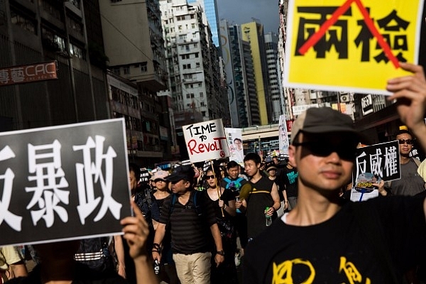 Activists hold banners and placards in Hong Kong. (ISAAC LAWRENCE/AFP/Getty Images)