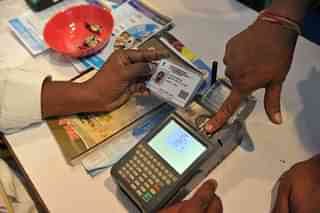 An Indian customer gives a thumb impression to withdraw money from his bank account with his Aadhaar card during a Digi Dhan Mela, held to promote digital payment, in Hyderabad. (NOAH SEELAM/AFP/GettyImages)