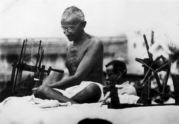 Gandhi at a spinning wheel during a ‘Charlea’ demonstration in Mirzapur, Uttar Pradesh. (Hulton Archive/GettyImages)