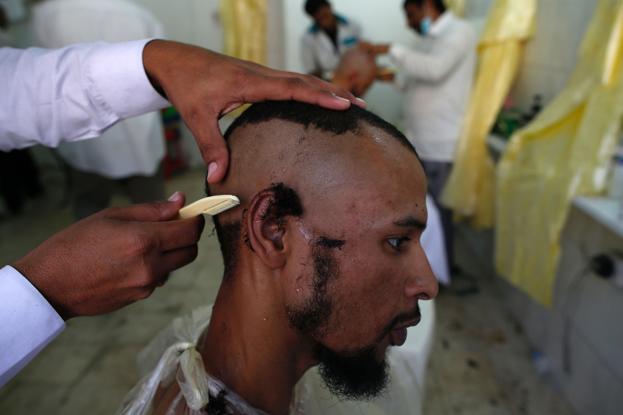 A Muslim man gets his head shaved in Saudi Arabia (AHMAD GHARABLI/AFP/Getty Images)