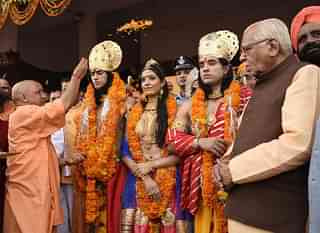 Uttar Pradesh CM Yogi Adityanath showers petals on artistes dressed up as Lord Rama, Sita and Lakshman in Ayodhya. (Deepak Gupta/Hindustan Times)