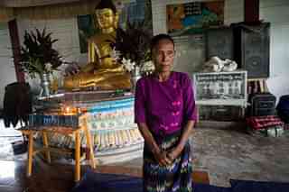 In this photograph taken on August 31, 2017 San Mae, 52, stands near a statue of Buddha at an internally displaced persons (IDP) camp in Sittwe. Rakhine, Myanmar’s poorest state, has become a crucible of religious hatred focused on the Muslim Rohingya, who are reviled and perceived as illegal immigrants in Buddhist-majority Myanmar. San Mae lives in Baw Di Kone in Rakhine State. This is the third time she has fled her village. (STR/AFP/Getty Images)