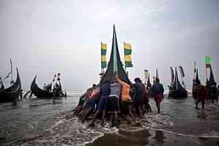 Rohingya men push a fishing boat to sea. (Shazia Rahman/Getty Images)