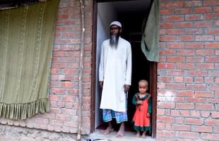 Rohingya refugee Haroon Rashid (L) poses with a child at the entrance to a building on the outskirts of Srinagar. (TAUSEEF MUSTAFA/AFP/Getty Images)