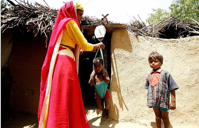 Indian Anganwadi worker weighs a 
malnourished child. (MANAN VATSYAYANA/AFP/Getty Images) 