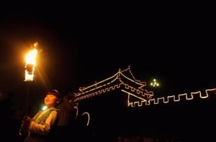 A girl holds a torch during an event to mark the Mid-Autumn Festival beside an ancient city wall in 2006 in Shouxian County of Anhui Province, China. (China Photos/Getty Images)