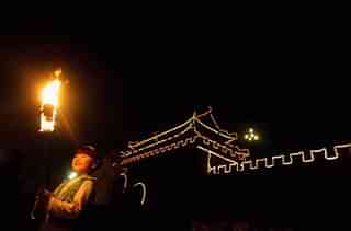  A girl holds a torch during an event to mark the Mid-Autumn Festival beside an ancient city wall in  2006 in Shouxian County of Anhui Province, China. (China Photos/Getty Images)
