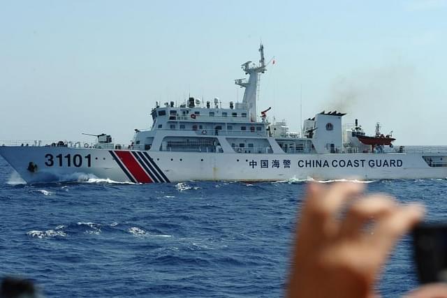 A Vietnamese coast guard officer taking pictures of a Chinese coast guard vessel near China’s oil drilling rig in disputed waters in the South China Sea in 2014. (HOANG DINH NAM/AFP via Getty Images)