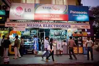 People make their way past an electronics retailer in Khan Market, New Delhi. (Daniel Berehulak/Getty Images)