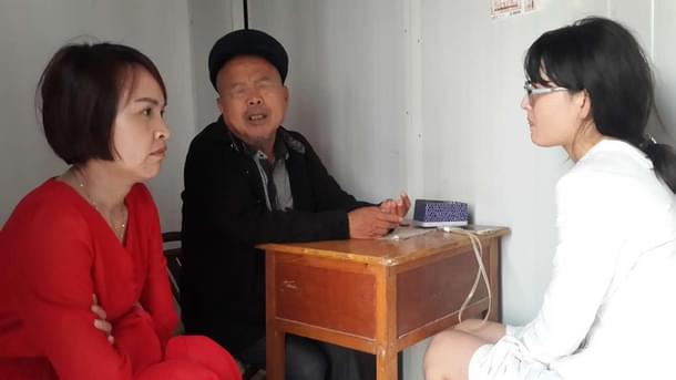 <i>Ayi</i> and Fan Yu intently listening to the ‘<i>suanming’</i> predict the outcomes.